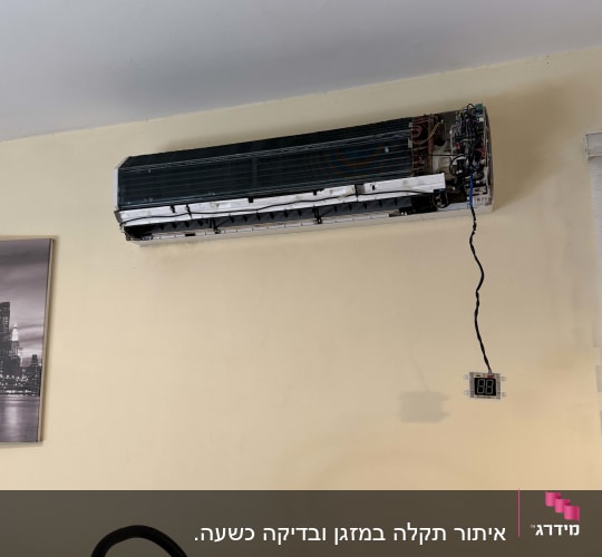 מזגן מפורק על קיר עם סולם לידו